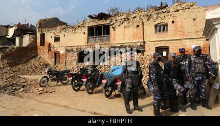 Kathmandu, Nepal. 16th Jan, 2016. Nepalese policemen stand guard in front of damaged buildings during the reconstruction inauguration at Bungamati in Lalitpur, Nepal, Jan. 16, 2016. Nepal on Saturday formally commenced the reconstruction process nearly nine months after the massive earthquake on April 25 last year. © Sunil Sharma/Xinhua/Alamy Live News Stock Photo