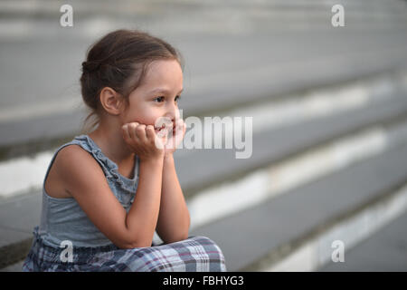 little girl sitting on stairs Stock Photo