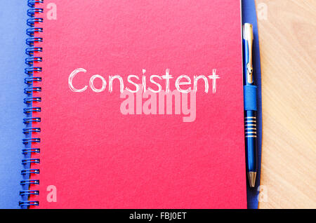 Consistent text concept write on notebook with pen Stock Photo