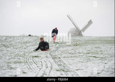 A boy slides down a snow-covered slope on a sledge in Clayton, East Sussex, UK. Stock Photo