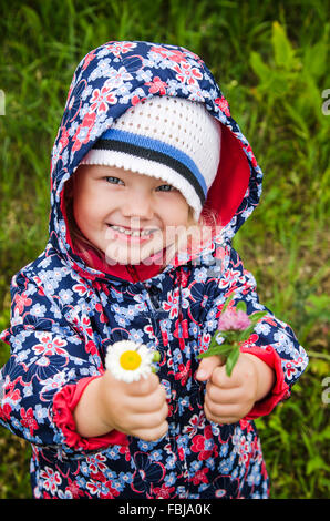 Portrait of a little girl with wild flowers in the hands Stock Photo