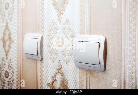 two white plastic switches on the wall closeup Stock Photo