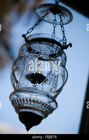 Hanging wind light of glass with candle in the evening light Stock Photo