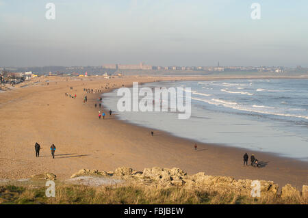 South Shields, UK. 17th January, 2016. Despite freezing temperatures walkers enjoy a glimpse of winter sunshine on Sandhaven beach in South Shields, South Tyneside. In the background Tynemouth is misty. Credit:  Washington Imaging/Alamy Live News Stock Photo
