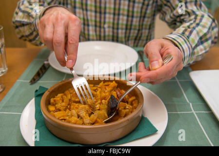 Man's hands serving Callos a la Madrileña in a restaurant, close view. Madrid, Spain. Stock Photo