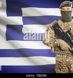 Soldier with machine gun and national flag on background series - Greece Stock Photo