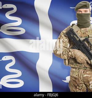 Soldier with machine gun and national flag on background series - Martinique Stock Photo