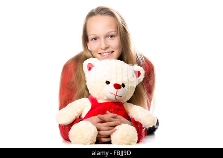 Portrait of happy beautiful casual teenage girl in red leather jacket hugging teddy bear, friendly smiling, looking at camera Stock Photo