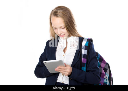 Portrait of smiling cute happy beautiful schoolgirl wearing school uniform, holding checkered bag and tablet, using app Stock Photo