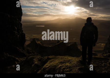 Person admiring the view, watching dramatic light over the Quiraing from The Table, Isle of Skye, Scotland, UK Stock Photo