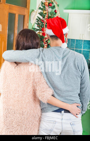 Married Couple Standing in Front of Fir Trees and Looking So Adorned in Decorations. Man and Woman in a Festive Mood. Waiting fo Stock Photo
