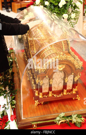 Worshipers place hands on the relics of St. Therese of Lisieux at Lady of Seven Sorrows church, Bratislava, Slovakia. Stock Photo