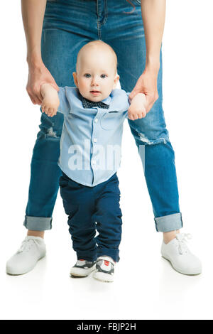 baby taking first steps with mother help Stock Photo