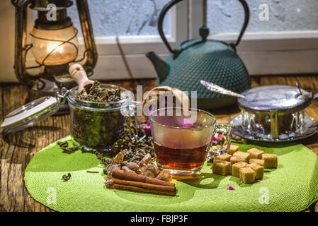 Kettle with green tea and a glass cup on a wooden table Stock Photo