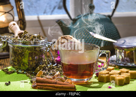 Kettle with green tea and a glass cup on a wooden table Stock Photo