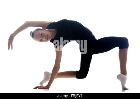 Beautiful happy smiling cool young fit gymnast athlete woman in sportswear doing art gymnastics, standing in backbend acrobatic Stock Photo
