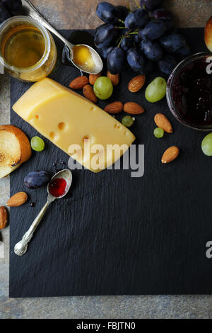 cheese and fruits on slate background, food top Stock Photo