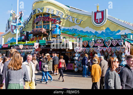 Festive crowd strolling under animated mannequins cooking ox on beer tent at Oktoberfest in Munich, Germany. Stock Photo