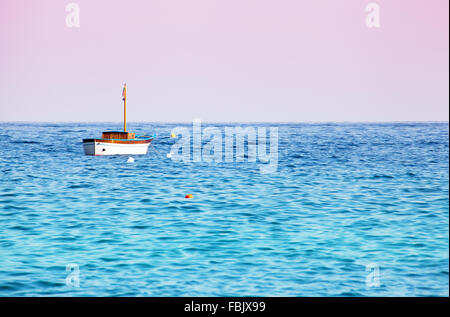 Lonely anchored boat in the sea Stock Photo
