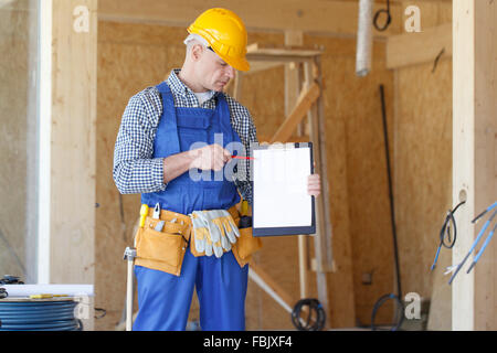 Portrait of foreman pointing at white folder plate Stock Photo