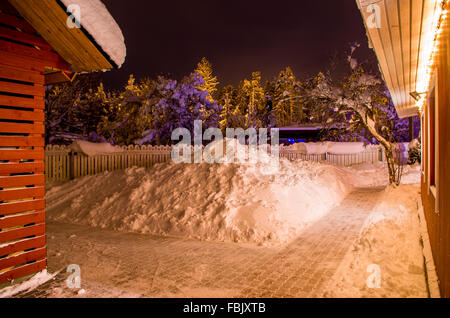 yard in winter with lots of snow lighted by christmas lights Stock Photo