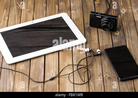 smart phone, tablet pc and headset on wooden background. Stock Photo