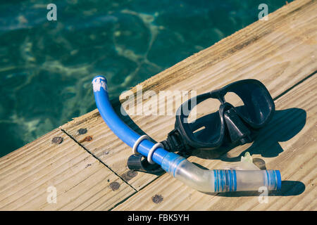 snorkel and mask on wooden pier by the ocean with special instagram filtered effect Stock Photo