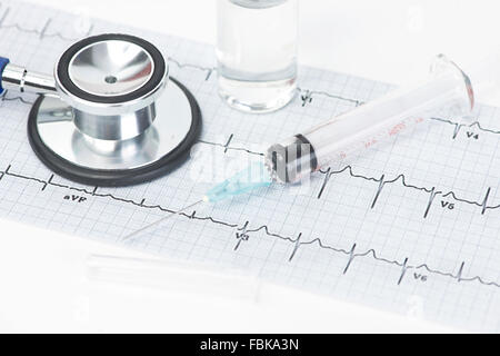 Electrocardiogram graph and stethoscope  with syringe and vial. Stock Photo