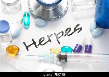 Herpes virus concept photo with pills, vials, and stethoscope. Stock Photo