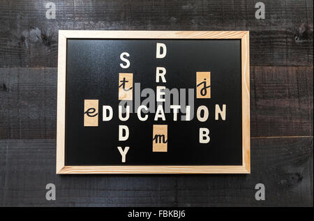 Wooden letters on chalkboard and wood background with a concept message about education concept Stock Photo