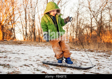 Boy snowboarding downhill Stock Photo