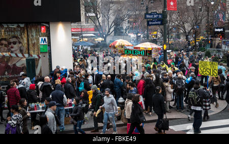 Huge crowd of people (shoppers and tourists) on 34th Street in New York City overspilling from the pavement into the road. Stock Photo