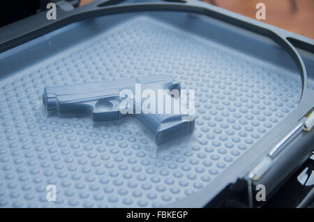 Black toy gun lying on  plastiv bubble surface, print screen process. Stock Photo