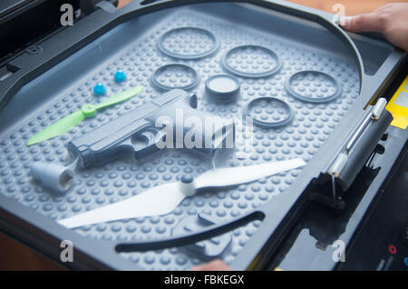 Black rubber rings, toy gun and small propellers lying on plastic bubble surface, print screen process. Stock Photo