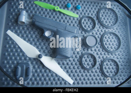Black rubber rings, toy gun and small propellers lying on plastic bubble surface, print screen process. Stock Photo