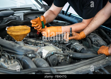 Two mechanics working on a vehicle in a garage Stock Photo