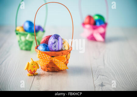 Color full easter eggs in a basket on a white table Stock Photo