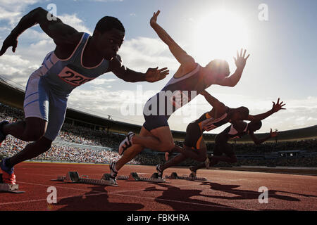 Athletes running on running track Stock Photo