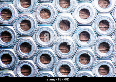 Chrome nuts on wooden background Stock Photo