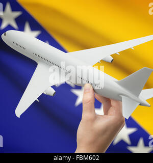 Airplane in hand with national flag on background series - Bosnia and Herzegovina Stock Photo