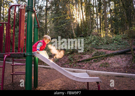 Boy on a slide in park Stock Photo