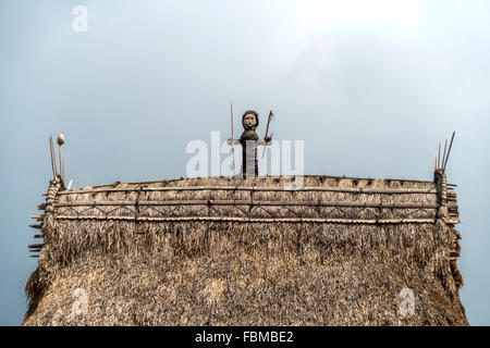 statue on the roof of a traditional high thatch-roofed houses in the Ngada village Bena near Bajawa, Flores, Indonesia, Asia Stock Photo