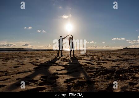Silhouette of a couple dancing on the beach Stock Photo