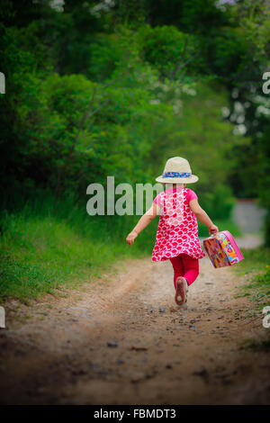 Girl running along footpath in forest Stock Photo