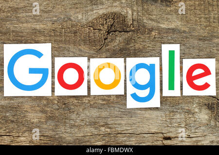 Kiev, Ukraine - January 12, 2016: New Google logotype printed on paper, cut and placed on old wood Stock Photo