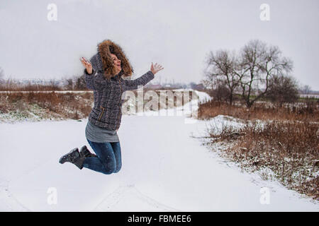 Mid adult woman jumping in the air Stock Photo