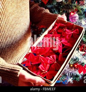 Close-up of a Man holding a box of red ribbons Stock Photo