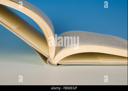 Open book spine resting on a table. Stock Photo