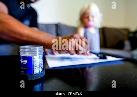 Crime scene investigator is looking for fingerprints after a burglary that happened the previous night through the nursery’s win Stock Photo