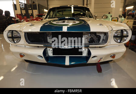 Front view of a classic pre 1966, first generation, Ford Mustang GT350 race car in the garage at the Silverstone Classic 2015. Stock Photo
